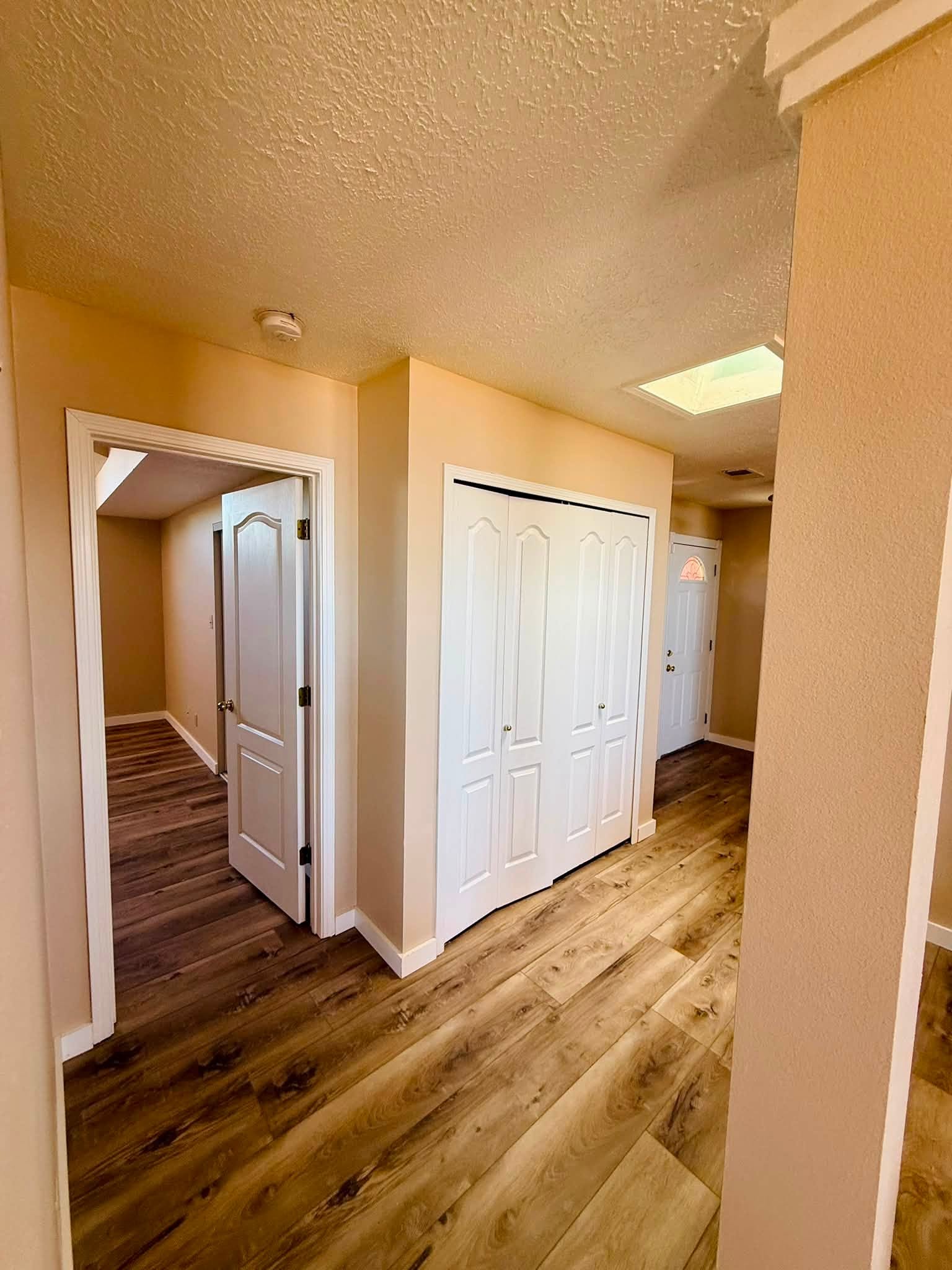 Painted hallway with white closet doors and contrasting neutral walls